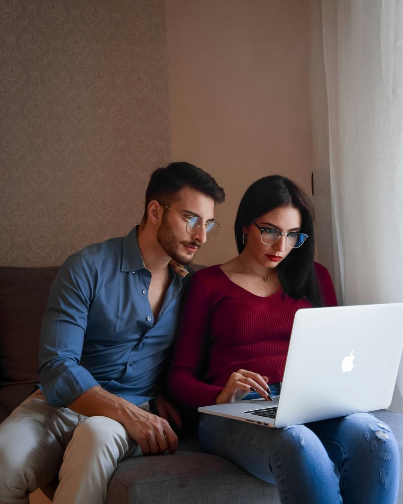 A couple on a sofa looking at a laptop together